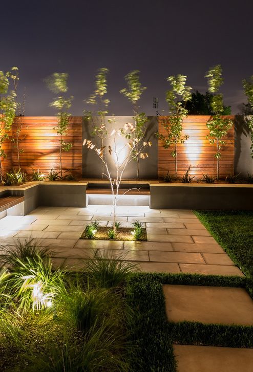 Luminária espeto de LED branco quente instalada em jardim, destacando plantas com iluminação suave e uniforme. Ideal para uso externo com proteção IP65
